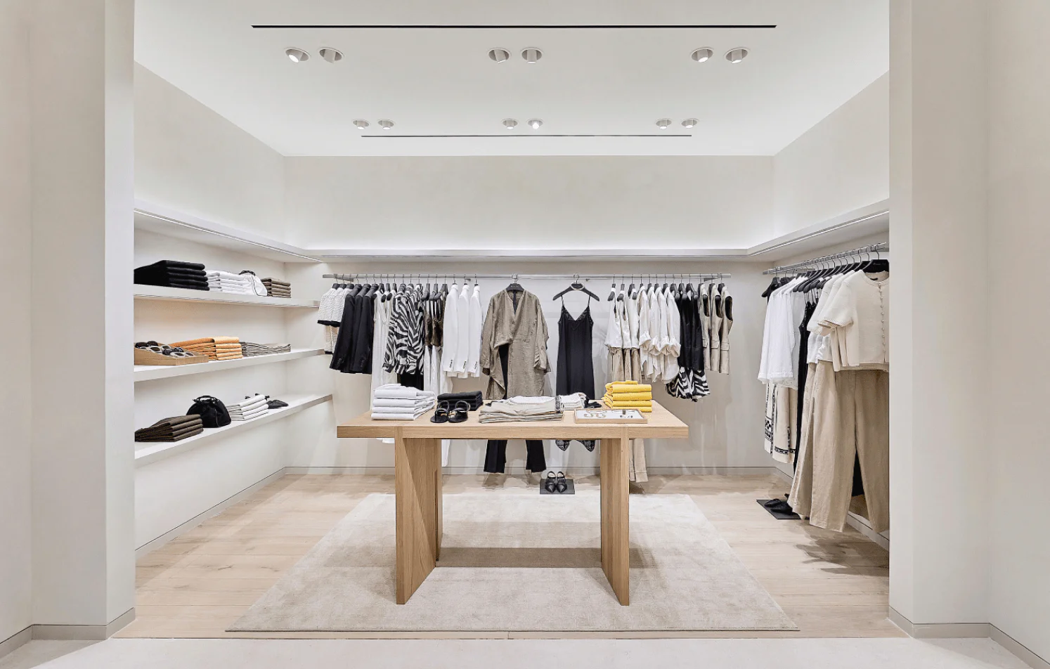 Modern fashion store interior design Minimalist clothing store interior with neutral tones and neatly arranged garments on racks and shelves