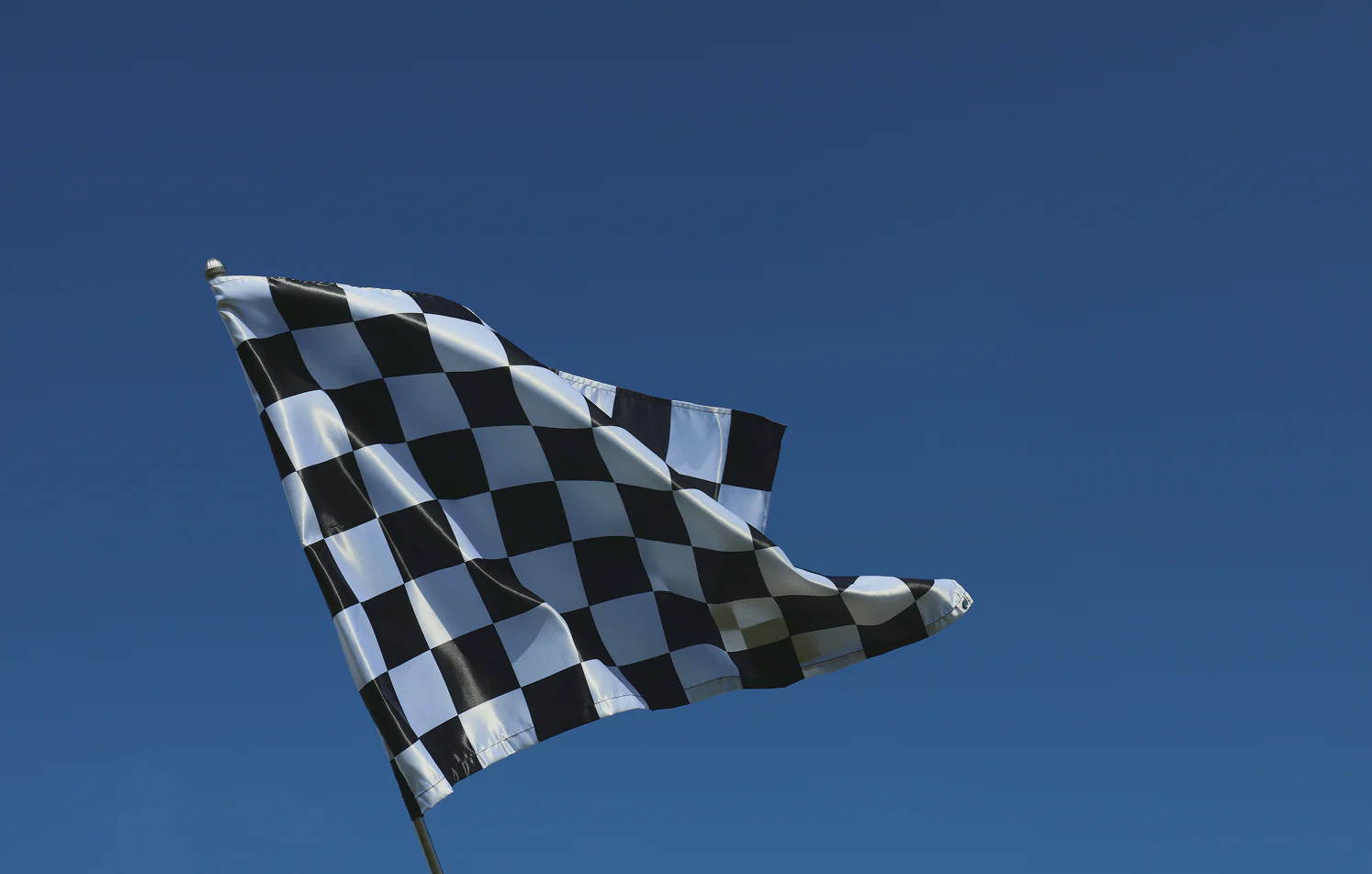 Checkered flag waving against blue sky