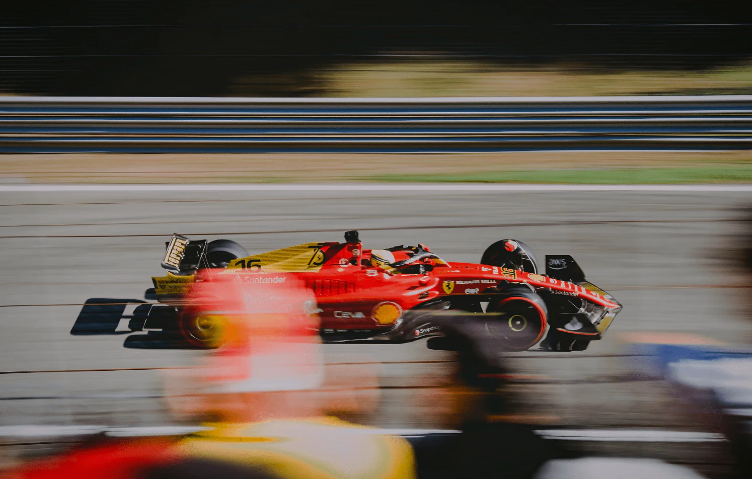 Red race car speeding on a track.