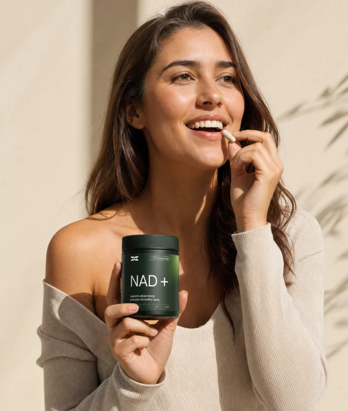 Woman taking a capsule and holding an NAD+ supplement jar