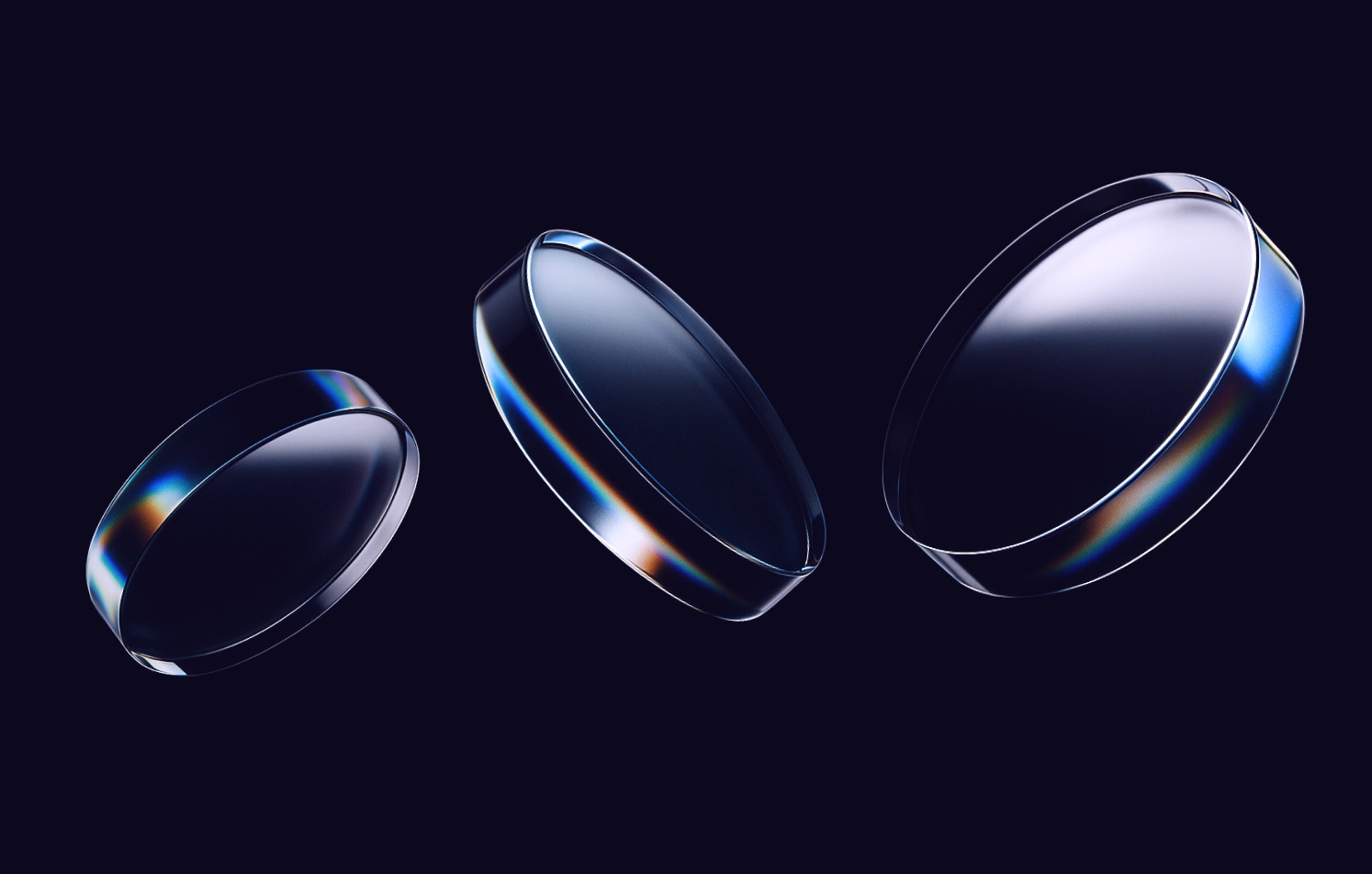 Abstract glass lenses with chromatic effects Three glass lenses with rainbow reflections on a dark background